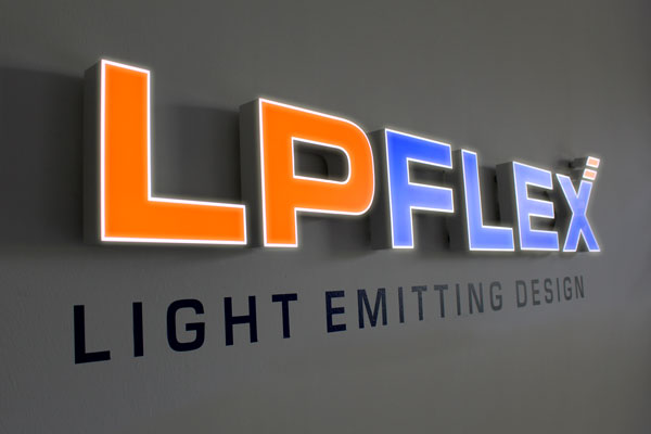 LP Flex-Logo aus Leuchtbuchstaben vor dunkler Wand